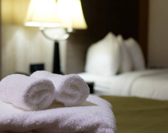 White towel on bed in guest room for hotel customer.